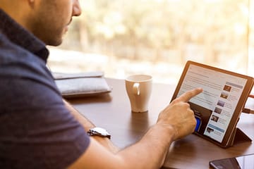 Homem consumindo infoprodutos em um tablet